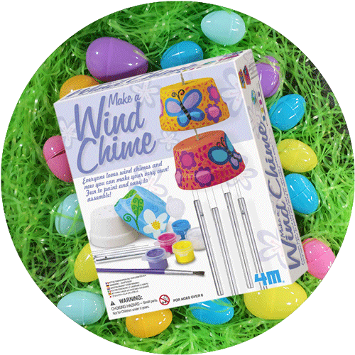A boxed kit for making your own wind chime, laying on green easter grass with colorful eggs around it.